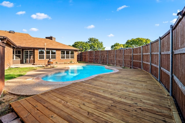 view of pool featuring a patio area and a wooden deck