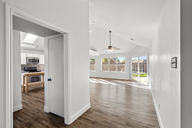 hallway featuring vaulted ceiling with skylight and dark wood-type flooring