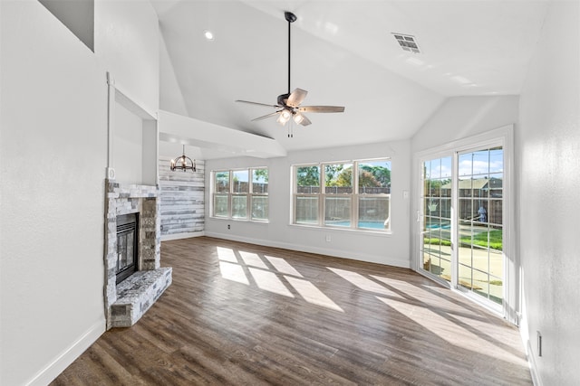 unfurnished living room featuring a stone fireplace, wood-type flooring, ceiling fan with notable chandelier, and vaulted ceiling