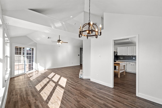 unfurnished living room with ceiling fan with notable chandelier, lofted ceiling, and dark hardwood / wood-style floors