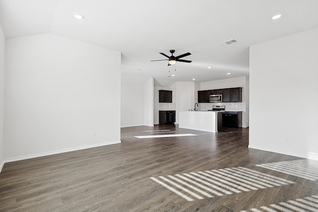 unfurnished living room featuring sink, ceiling fan, vaulted ceiling, and dark hardwood / wood-style flooring