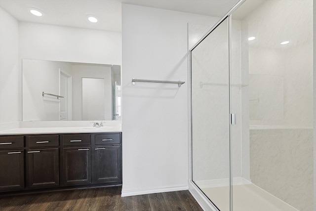 bathroom with vanity, a shower with shower door, and wood-type flooring