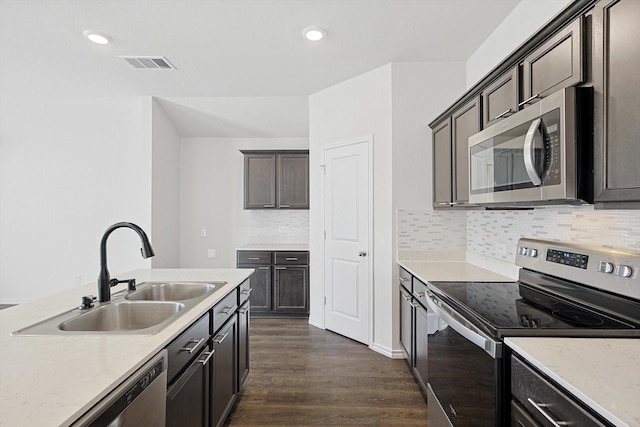 11120 W Pond Dr, Providence Village, TX 76227 - kitchen featuring appliances with stainless steel finishes, a sink, dark wood finished floors, decorative backsplash, and dark brown cabinets