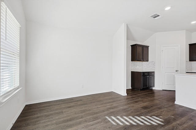 unfurnished living room with dark hardwood / wood-style floors and vaulted ceiling