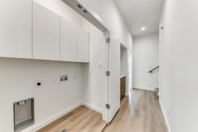 laundry room with cabinets, hookup for a washing machine, electric dryer hookup, hookup for a gas dryer, and light hardwood / wood-style floors