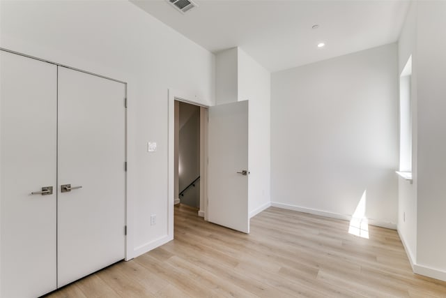 unfurnished bedroom featuring light hardwood / wood-style flooring and a closet