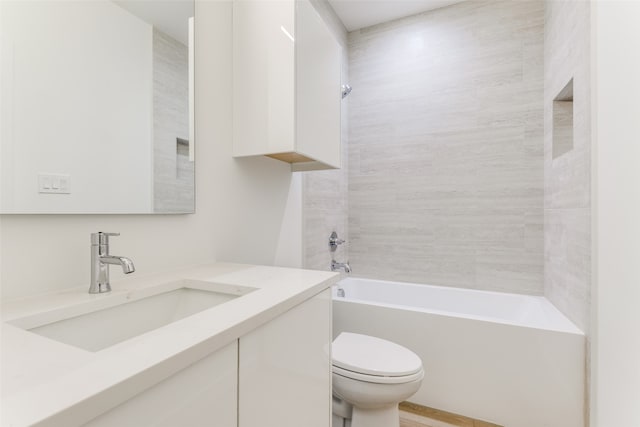 full bathroom with toilet, tiled shower / bath, and vanity