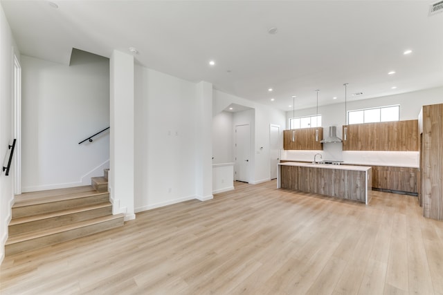 unfurnished living room with sink and light hardwood / wood-style flooring