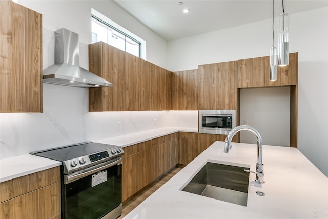 kitchen featuring sink, dark hardwood / wood-style flooring, stainless steel appliances, pendant lighting, and exhaust hood