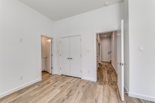 unfurnished bedroom with a closet and light wood-type flooring