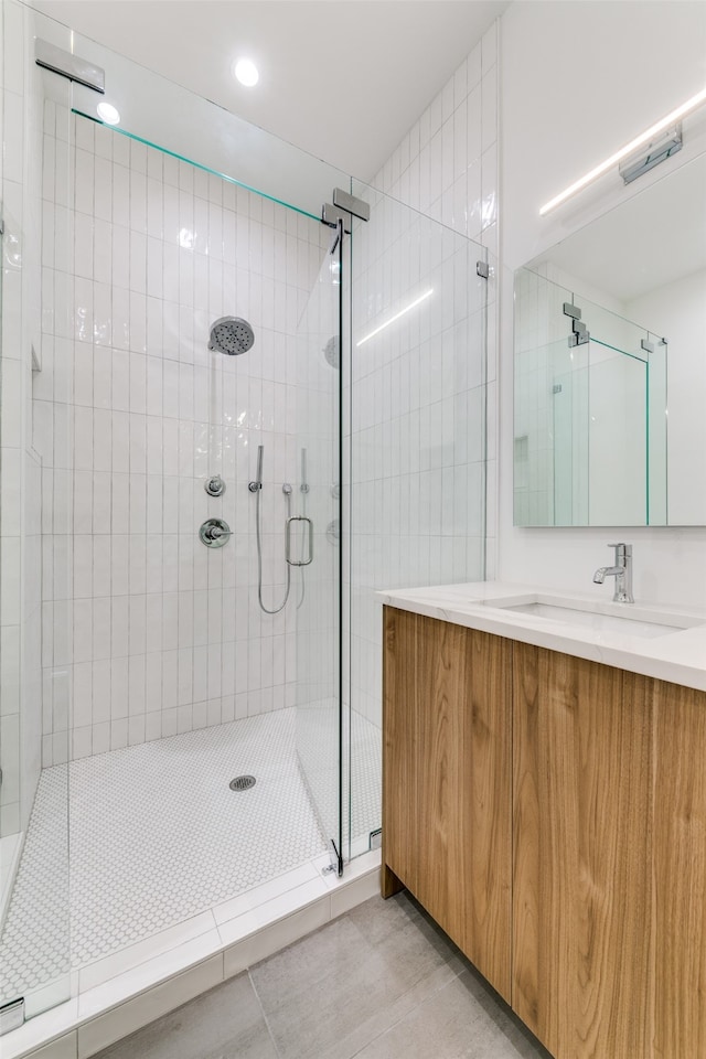 bathroom with vanity, a shower with shower door, and tile patterned flooring