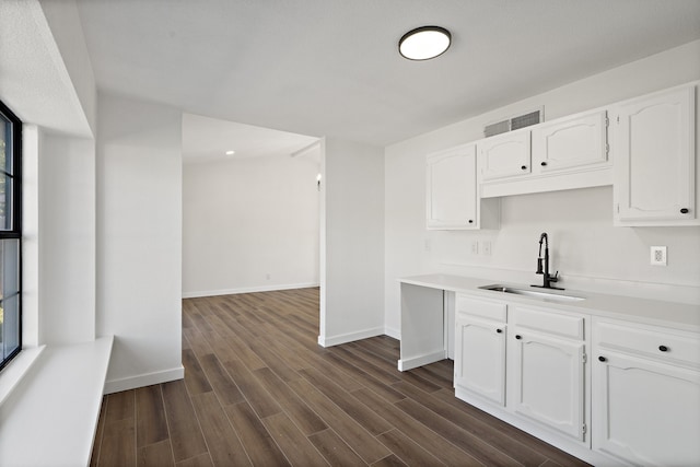 kitchen with white cabinetry, sink, and dark wood-type flooring