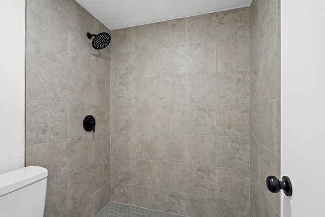 bathroom with toilet and tiled shower