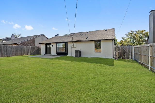 rear view of house featuring central air condition unit, a patio area, and a lawn