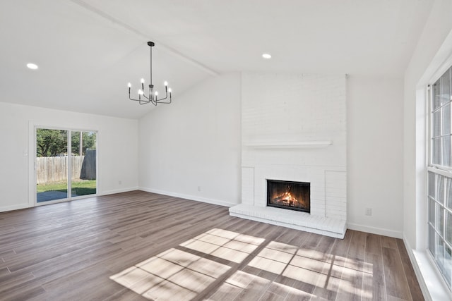 unfurnished living room featuring vaulted ceiling with beams, hardwood / wood-style flooring, a chandelier, and a fireplace