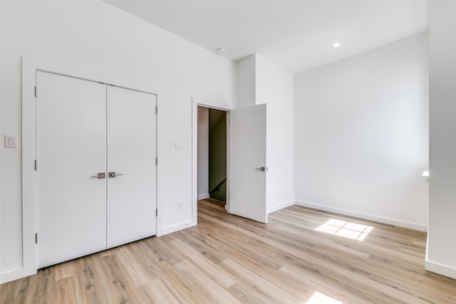 unfurnished bedroom featuring light hardwood / wood-style flooring and a closet