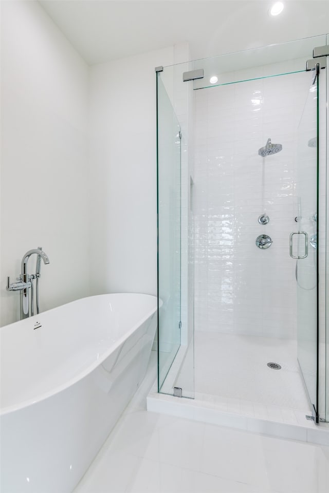 bathroom featuring independent shower and bath and tile patterned flooring