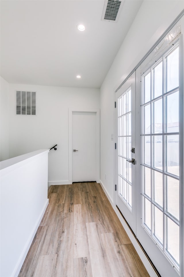 corridor featuring french doors and light hardwood / wood-style flooring