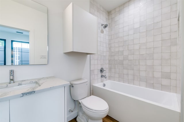 full bathroom with toilet, tiled shower / bath combo, and vanity