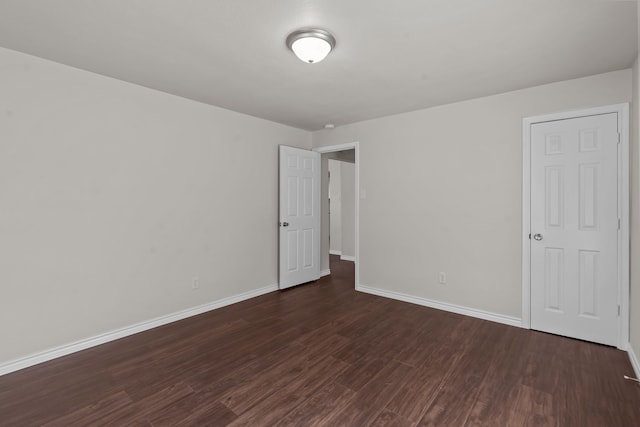 empty room with dark hardwood / wood-style flooring