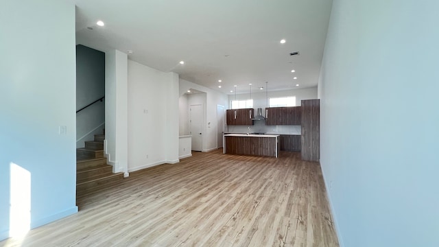 unfurnished living room with sink and light hardwood / wood-style flooring