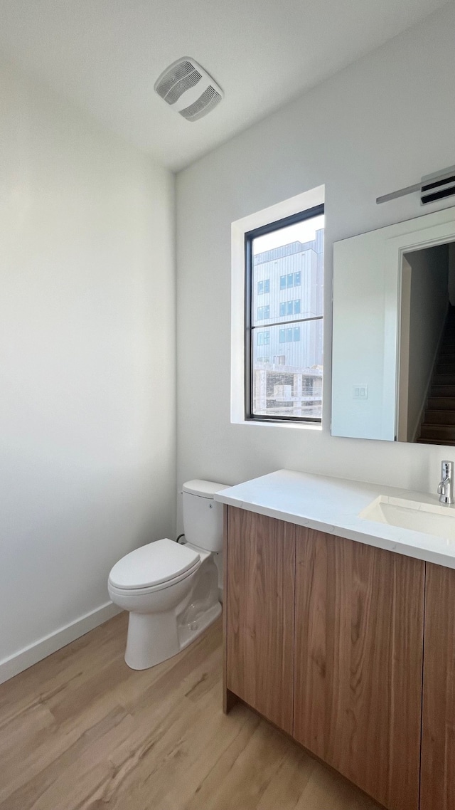 bathroom featuring toilet, hardwood / wood-style flooring, and vanity