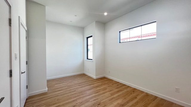 spare room featuring light wood-type flooring and plenty of natural light