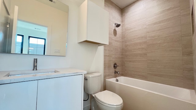 full bathroom featuring vanity, tiled shower / bath combo, and toilet