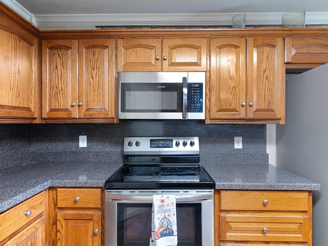 kitchen with appliances with stainless steel finishes, crown molding, and decorative backsplash