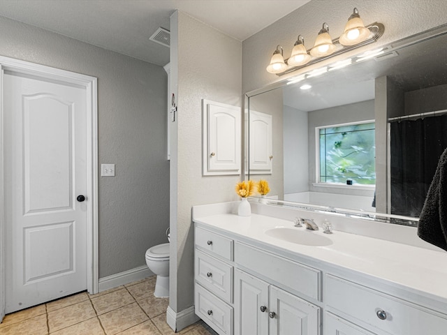 bathroom with vanity, toilet, and tile patterned floors