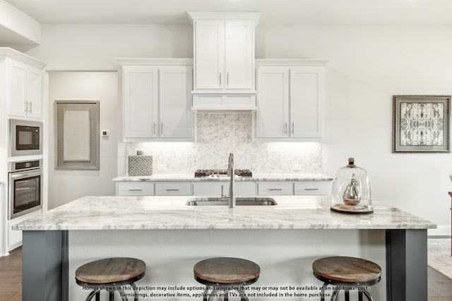 kitchen featuring white cabinets, light stone counters, dark hardwood / wood-style floors, and oven