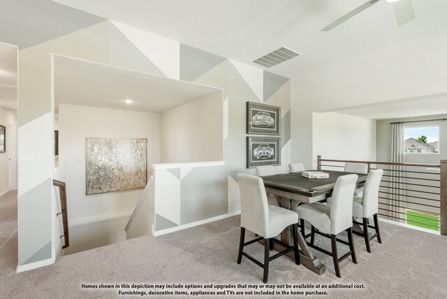 carpeted dining room with ceiling fan