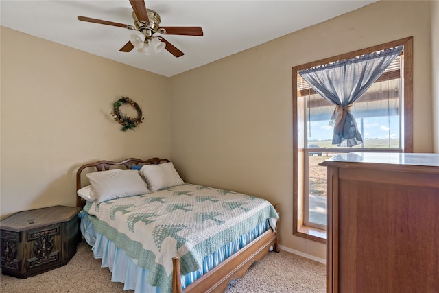 bedroom featuring ceiling fan, light carpet, and multiple windows