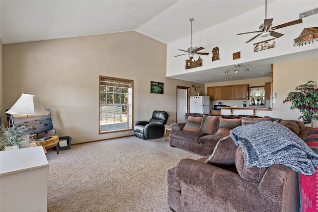 carpeted living room featuring high vaulted ceiling and ceiling fan