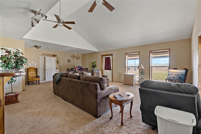 living room featuring ceiling fan with notable chandelier, a textured ceiling, vaulted ceiling, and light colored carpet