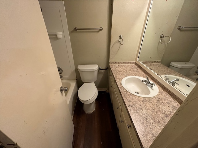 bathroom with toilet, vanity, and wood-type flooring