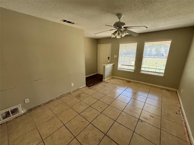 503 S Kaufman St, Seagoville, TX 75159 - empty room with a ceiling fan, a textured ceiling, light tile patterned floors, and baseboards