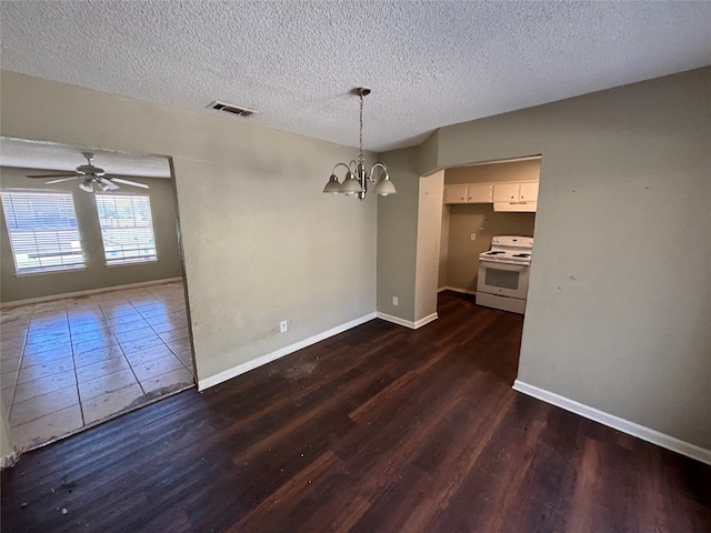 unfurnished dining area featuring dark wood-type flooring, a textured ceiling, and ceiling fan with notable chandelier