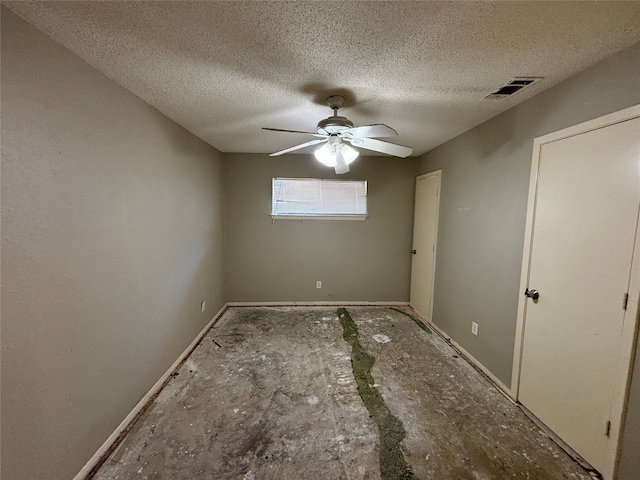 unfurnished bedroom with ceiling fan and a textured ceiling