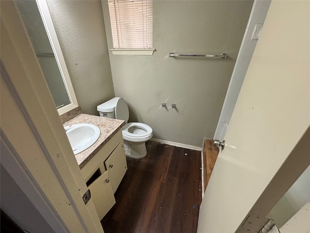 bathroom with vanity, toilet, and hardwood / wood-style floors