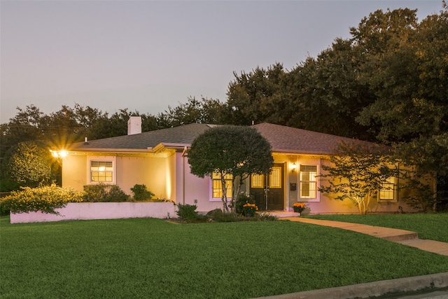 single story home with a lawn