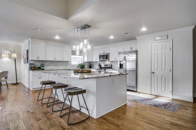 kitchen with light hardwood / wood-style flooring, stainless steel appliances, and a kitchen island