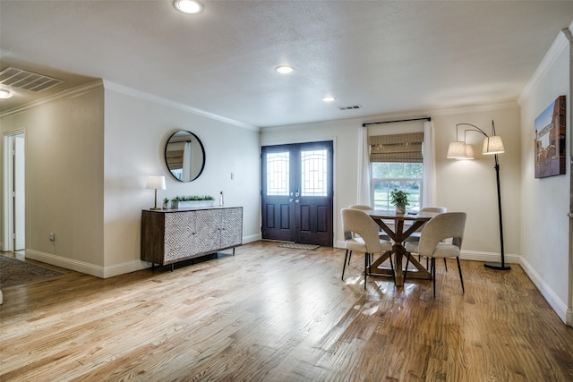 dining room with french doors, crown molding, and wood-type flooring