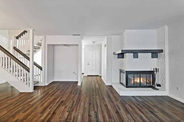 unfurnished living room with a multi sided fireplace and dark wood-type flooring