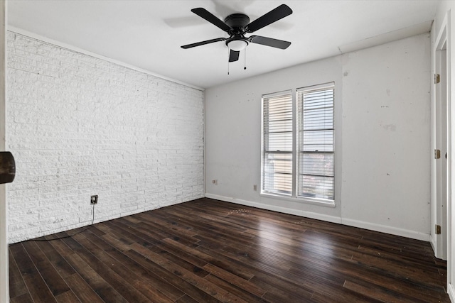 unfurnished room with dark hardwood / wood-style flooring, ceiling fan, and brick wall