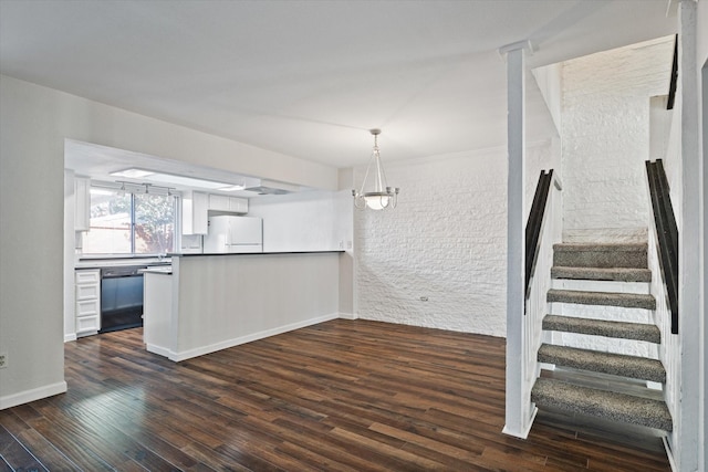 kitchen featuring white refrigerator, dark hardwood / wood-style floors, white cabinetry, and hanging light fixtures