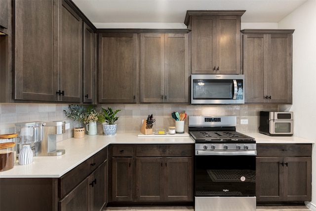 kitchen featuring decorative backsplash, appliances with stainless steel finishes, and dark brown cabinets