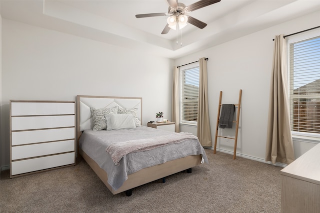 bedroom with ceiling fan, carpet, and a tray ceiling