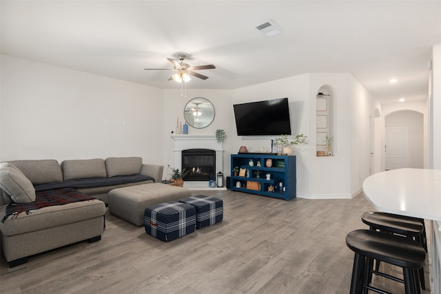 living room featuring hardwood / wood-style floors and ceiling fan