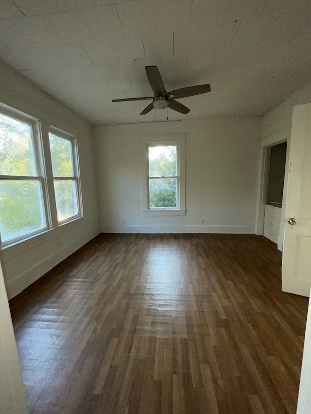 empty room with dark wood-type flooring and ceiling fan